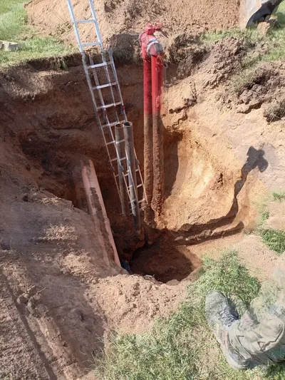 Głęboki wykop pod instalację P-POŻ z drabiną i nowymi rurami hydrantowymi